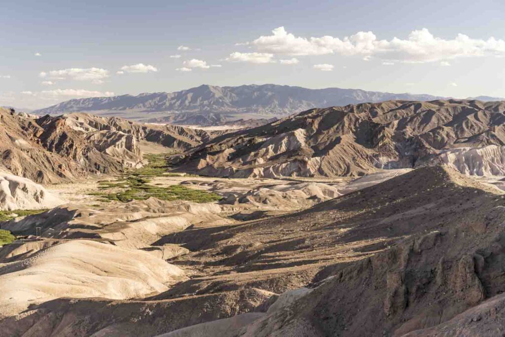 Vast desert canyon with mountains and watery green area